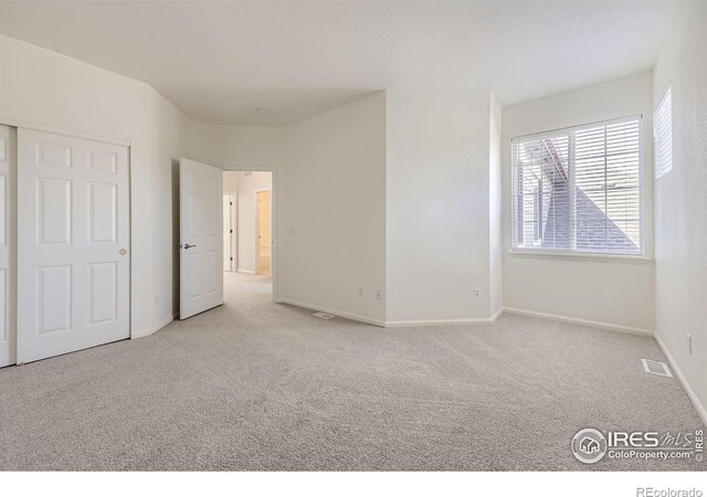 unfurnished bedroom featuring light carpet