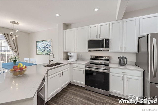 kitchen with kitchen peninsula, sink, stainless steel appliances, and white cabinets