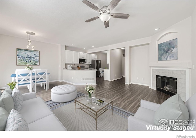 living room featuring dark hardwood / wood-style floors, ceiling fan, and sink