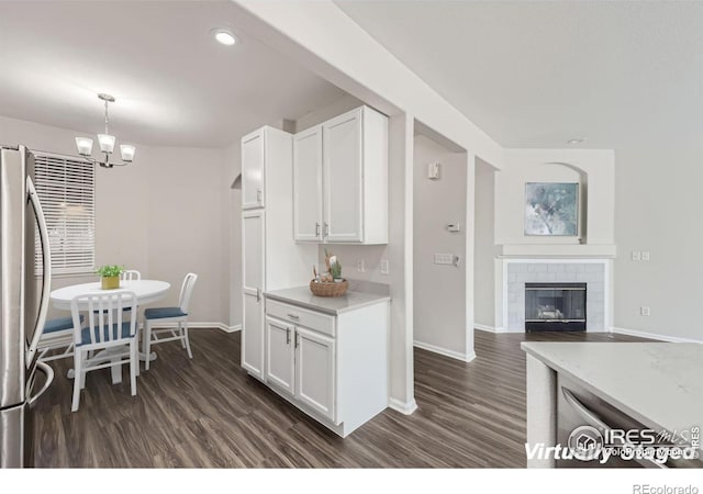 kitchen featuring pendant lighting, white cabinetry, dark hardwood / wood-style floors, and stainless steel fridge