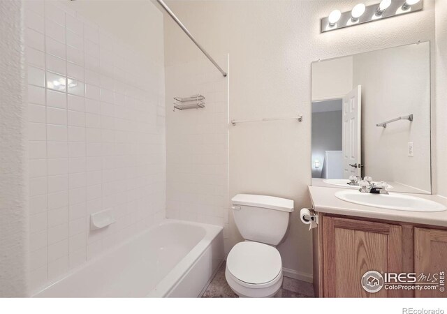 full bathroom featuring tiled shower / bath, vanity, and toilet