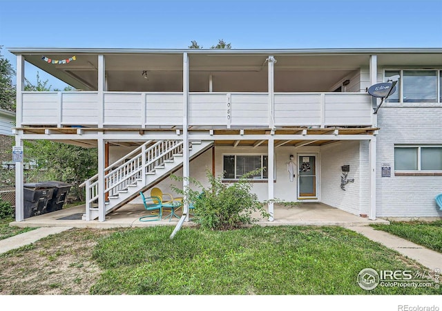 back of house featuring a balcony, a lawn, and a patio