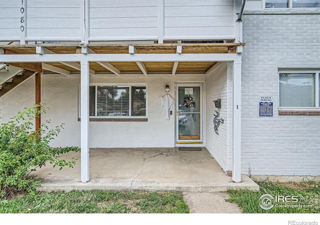 view of exterior entry with a patio