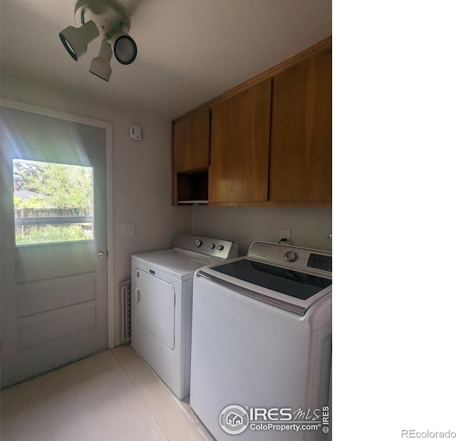 laundry room featuring cabinets and washer and dryer