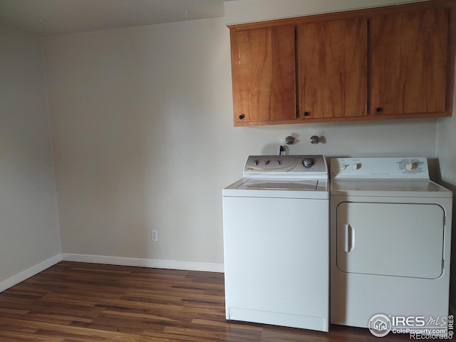 clothes washing area featuring separate washer and dryer, cabinets, and dark hardwood / wood-style floors