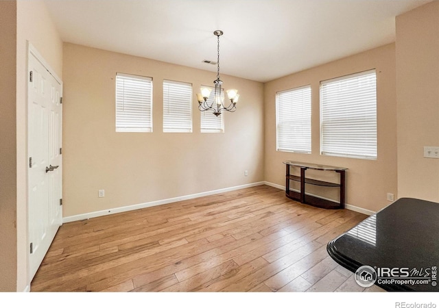 dining area with an inviting chandelier and light hardwood / wood-style flooring