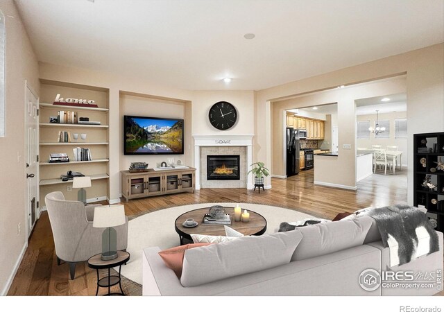 living room featuring a chandelier, hardwood / wood-style flooring, and a fireplace