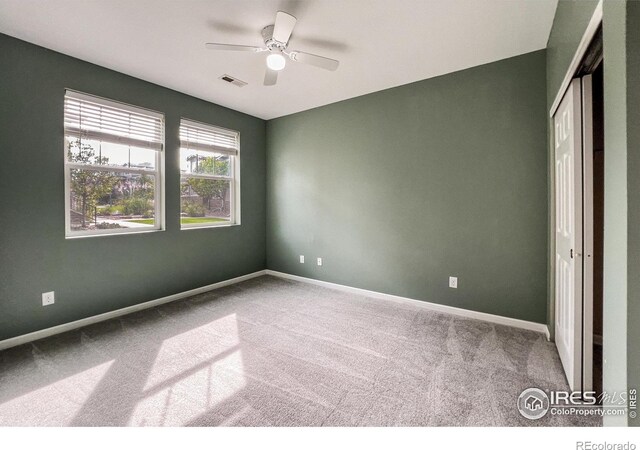 carpeted empty room featuring ceiling fan