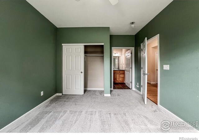 unfurnished bedroom featuring carpet, a closet, and ensuite bath