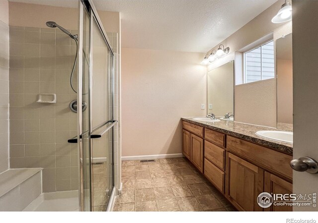 bathroom featuring vanity, a textured ceiling, and walk in shower