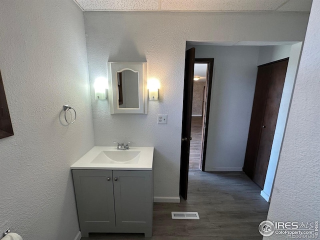 bathroom with vanity, a textured ceiling, and hardwood / wood-style floors