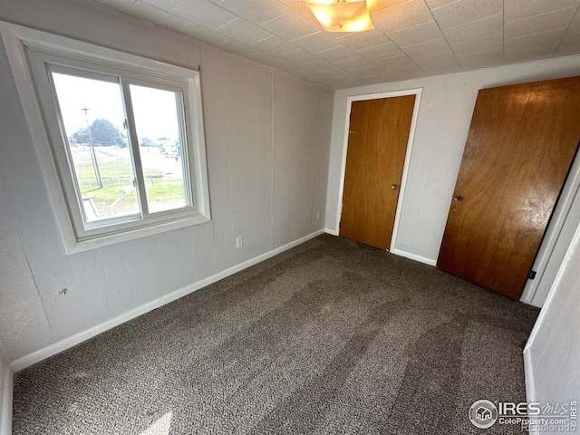 unfurnished bedroom with dark carpet