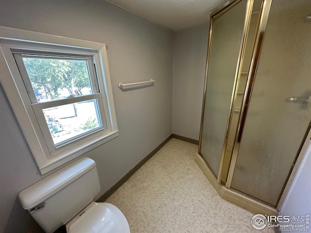 bathroom with toilet and a shower with door