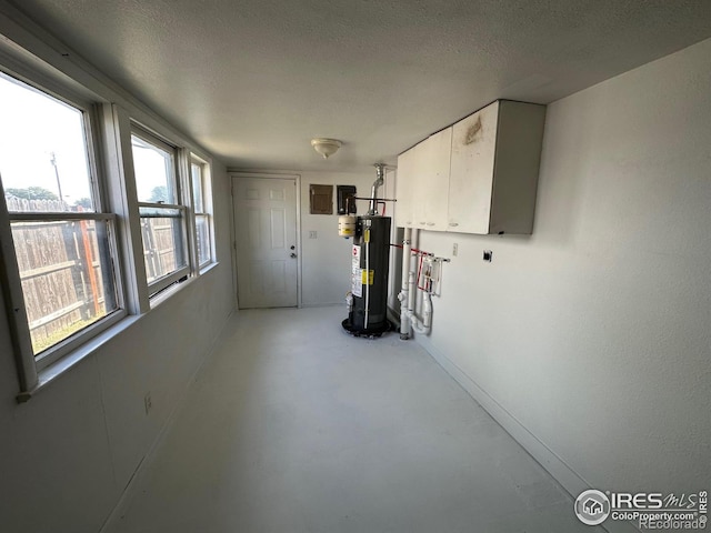 interior space featuring gas water heater, a textured ceiling, and a healthy amount of sunlight