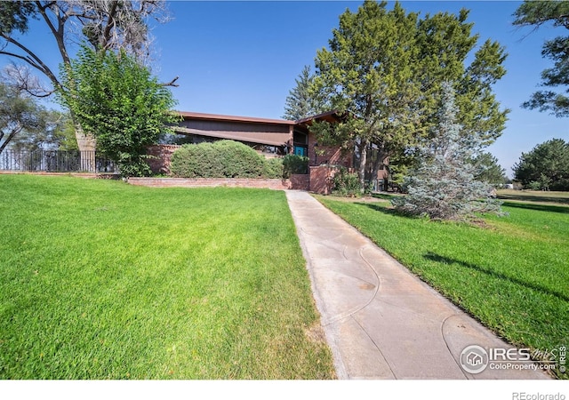 view of property hidden behind natural elements featuring a front yard