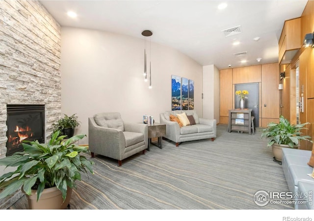 living room featuring carpet flooring and a stone fireplace