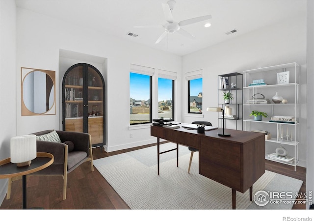 home office with ceiling fan and dark hardwood / wood-style floors