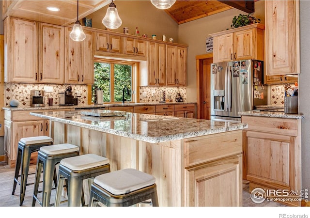 kitchen featuring stainless steel fridge, tasteful backsplash, a center island, vaulted ceiling with beams, and light brown cabinets