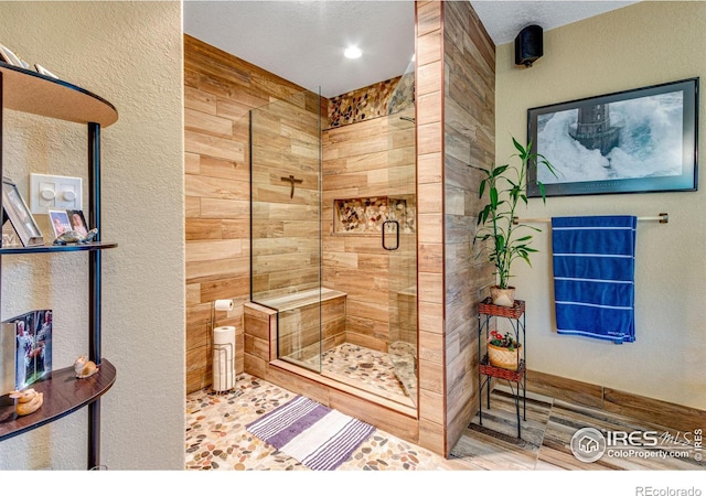 bathroom with a textured ceiling and a shower with shower door