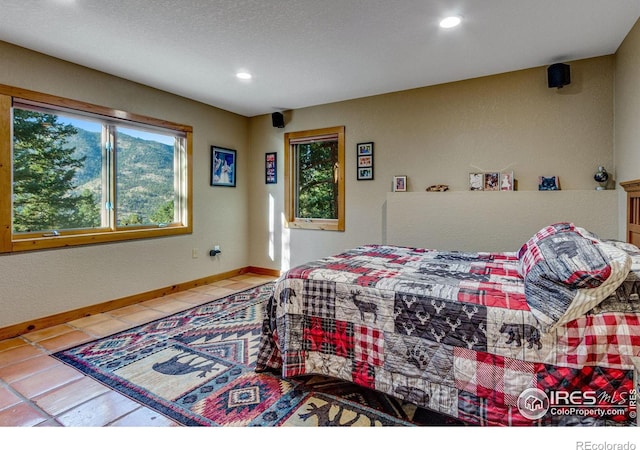 tiled bedroom featuring a textured ceiling