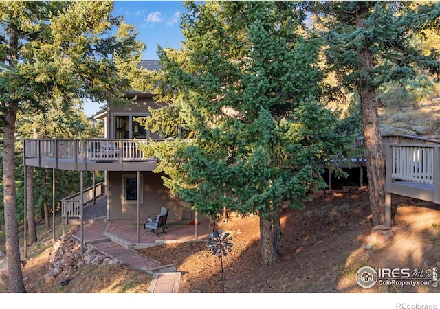 rear view of house featuring a patio and a deck