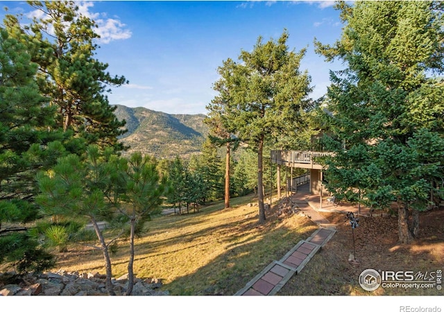 view of yard featuring a deck with mountain view