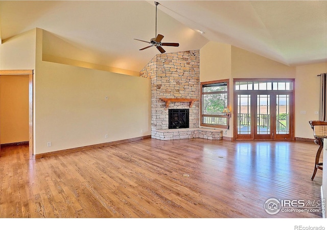 unfurnished living room with light hardwood / wood-style flooring, ceiling fan, high vaulted ceiling, and a fireplace