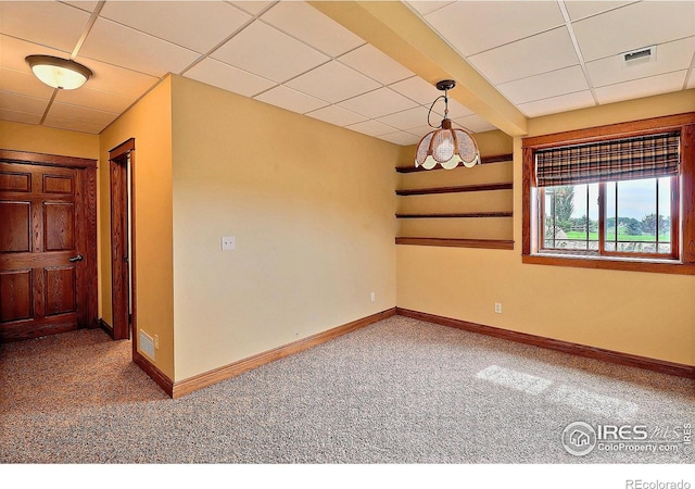 carpeted spare room featuring a paneled ceiling