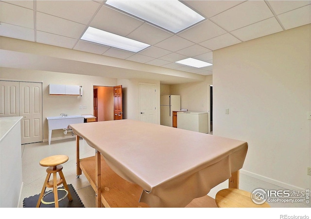 kitchen with a drop ceiling, white cabinetry, refrigerator, and white fridge