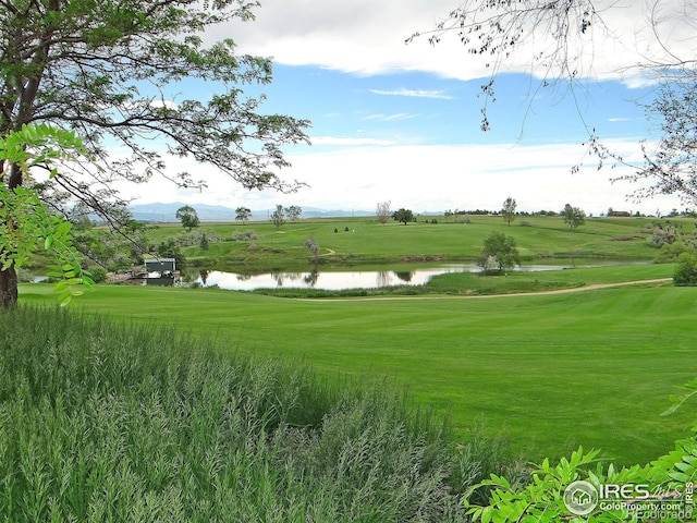 surrounding community featuring a lawn and a water view