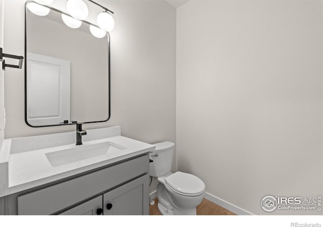 bathroom with vanity, hardwood / wood-style flooring, and toilet