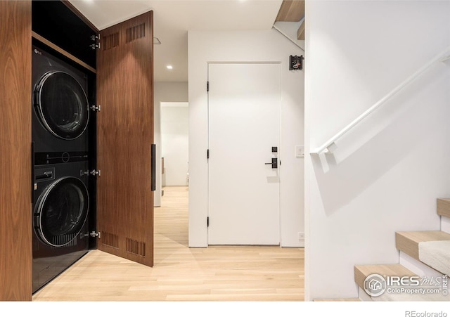 washroom featuring stacked washing maching and dryer and hardwood / wood-style floors