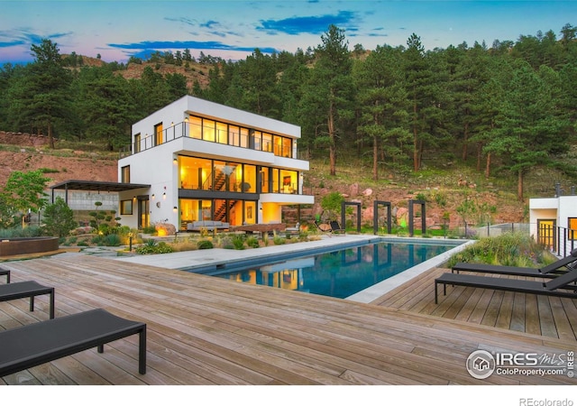 pool at dusk with a wooden deck