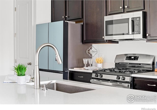 kitchen featuring dark brown cabinets, sink, and appliances with stainless steel finishes