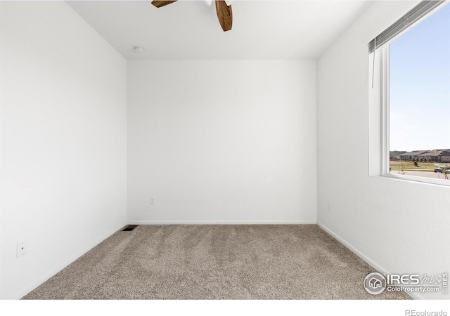 spare room with ceiling fan and light carpet