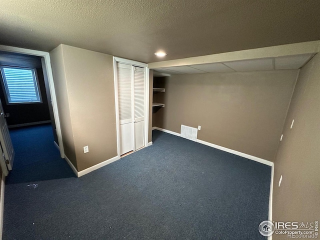 unfurnished bedroom with a textured ceiling and carpet