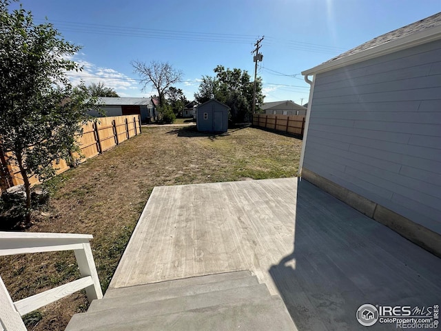 view of yard featuring a storage shed and a patio area