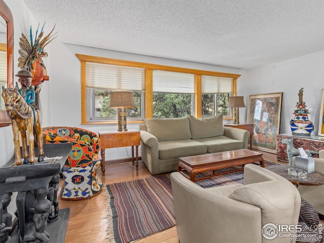 living room with a textured ceiling, hardwood / wood-style flooring, and a wealth of natural light