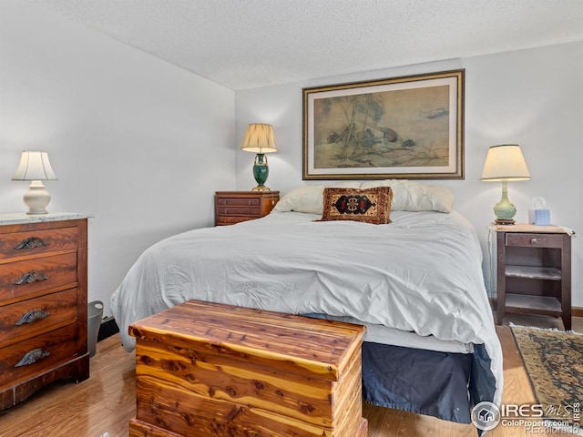 bedroom featuring a textured ceiling and hardwood / wood-style floors