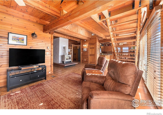 living room with wood walls, ceiling fan, beamed ceiling, and wooden ceiling