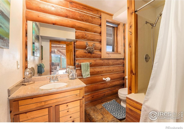 bathroom featuring rustic walls, curtained shower, vanity, and toilet