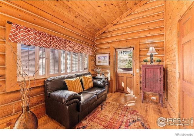 living room with wood ceiling, rustic walls, light hardwood / wood-style floors, and high vaulted ceiling