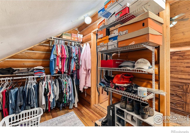 walk in closet with wood-type flooring and vaulted ceiling