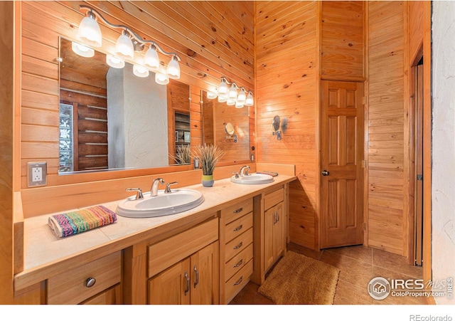 bathroom featuring vanity, wood walls, and tile patterned flooring