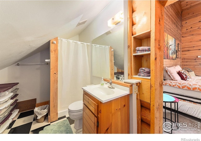 bathroom with lofted ceiling, wood walls, a shower with curtain, vanity, and toilet