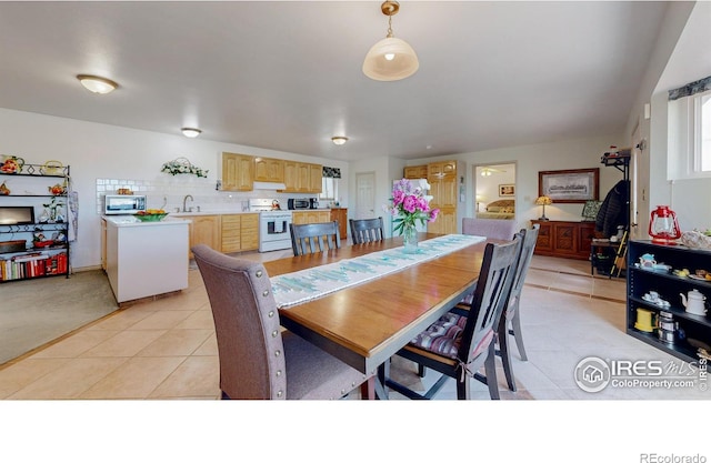 dining space with sink and light tile patterned flooring