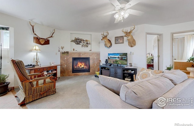 carpeted living room with a fireplace and ceiling fan