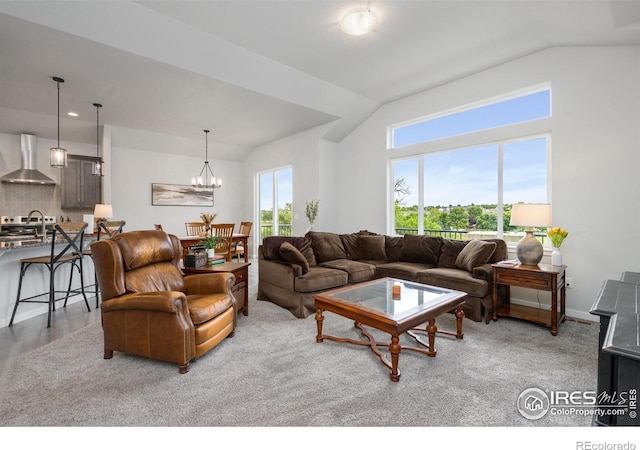 living area with baseboards, wood finished floors, an inviting chandelier, and vaulted ceiling