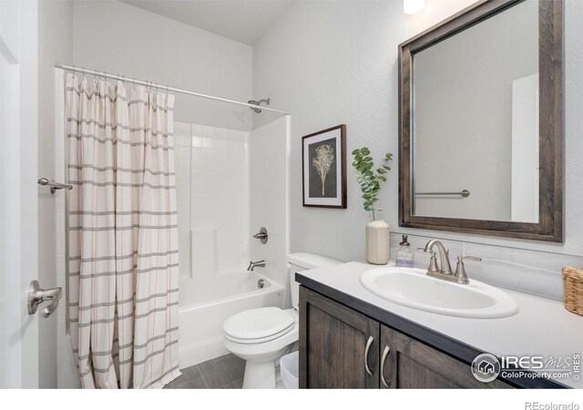 full bathroom featuring shower / bath combination with curtain, vanity, and toilet