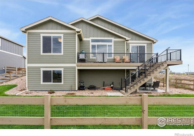 back of property featuring stairs, a patio, a fenced backyard, and board and batten siding